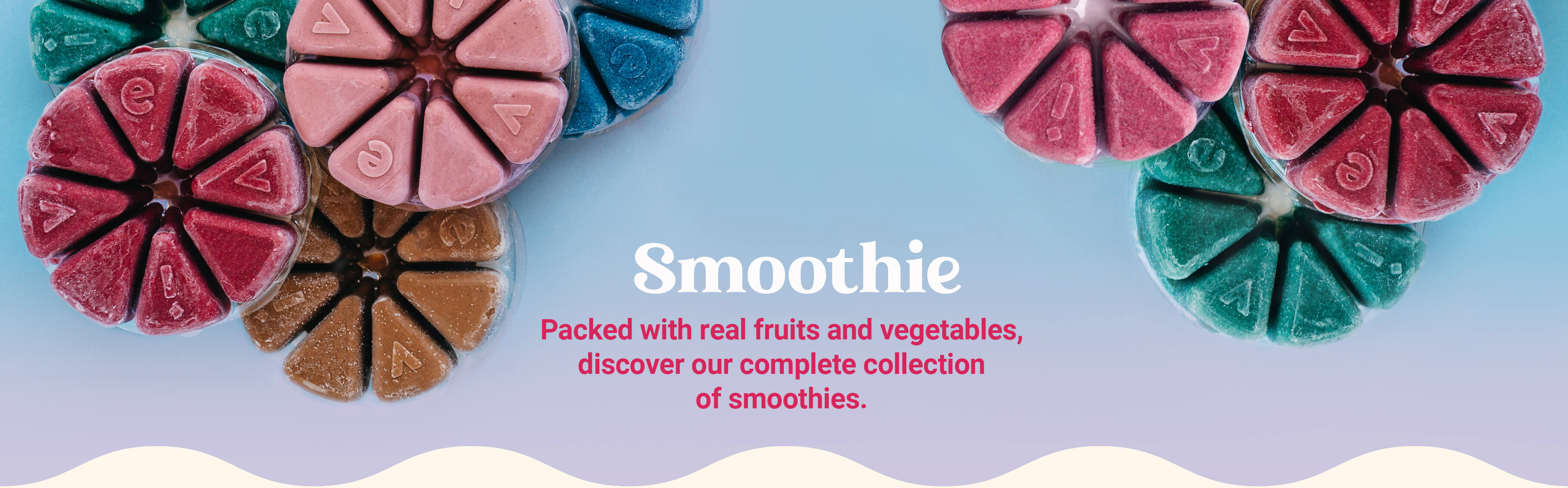 An overhead shot of colorful Evive Smoothie Bites, two product bags, and a white portable blender.